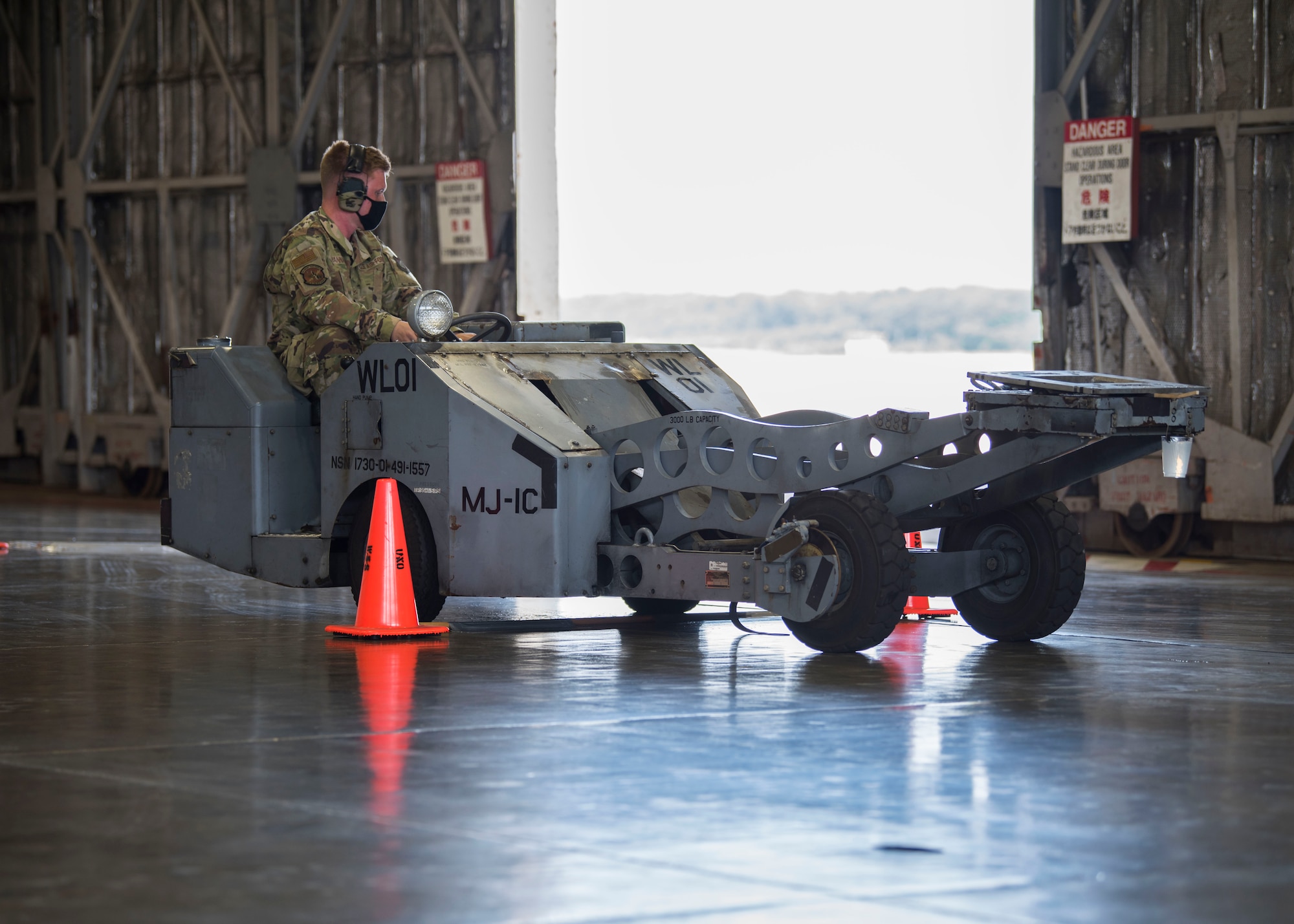 U.S. military member operates a vehicle in reverse while it carries a cup of water.