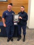 Lt. Cmdr. Stephanie Woods accepts 2020 DHS Chief Readiness Support Office Supervisor of the Year award, presented by Capt. Joshua P. Miller, commanding officer, Base National Capital Region, July 7, 2021. U.S. Coast Guard photo taken by Noelle Slager.