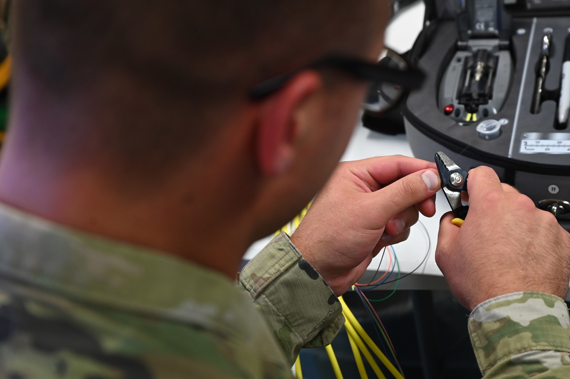 U.S. Air Force Senior Airman Brandon Allen, 1st Communication Maintenance Squadron cable and antenna theater maintenance technician, strips a wire during a demonstration at Ramstein Air Base, Germany, July 13, 2021. The 1st CMXS is responsible for ensuring their customers are supported with network and cable infrastructure so they can do their jobs without the worry of degraded communication capabilities. (U.S. Air Force photo by Senior Airman Thomas Karol)