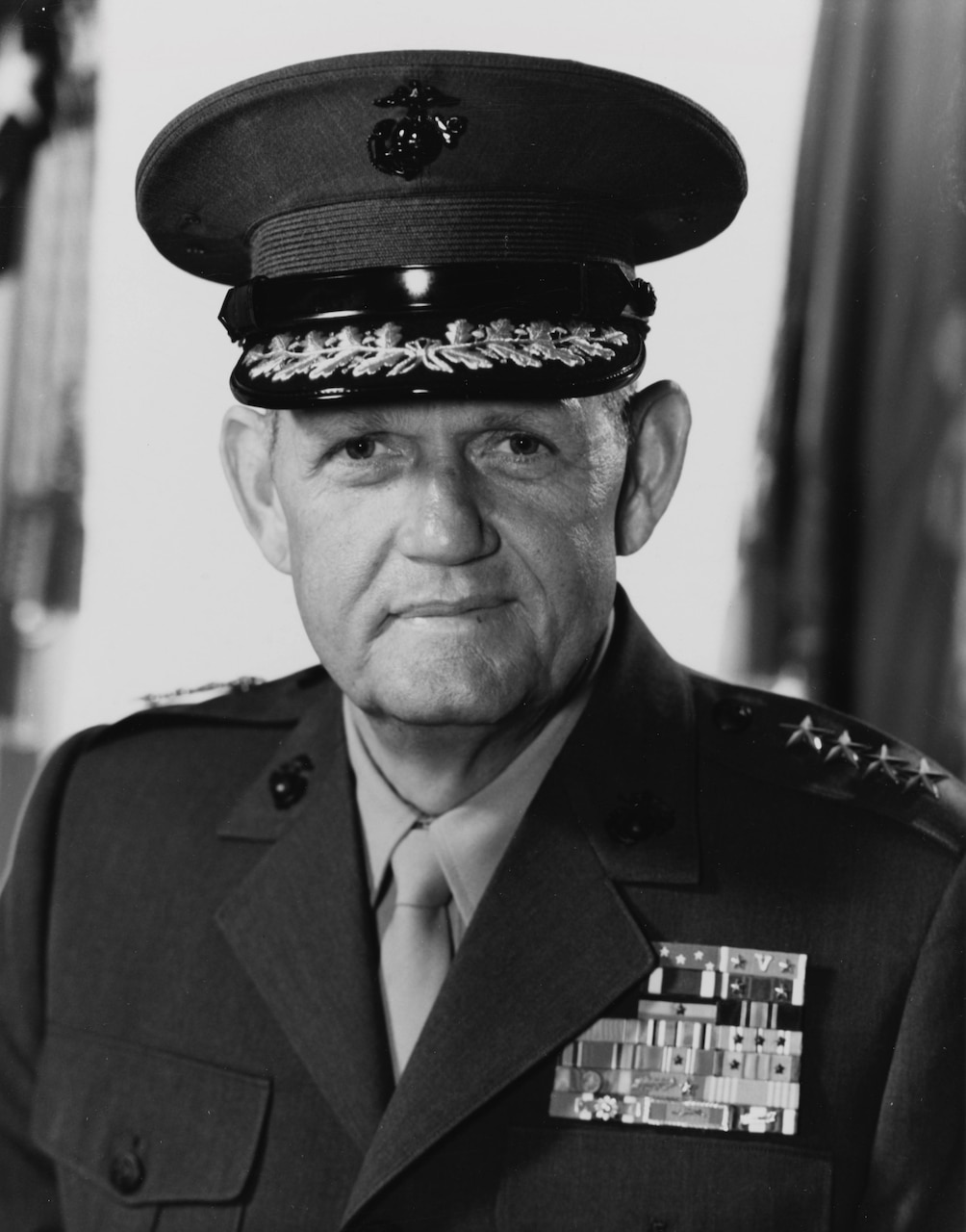 A man in dress uniform and cap poses for a photo.