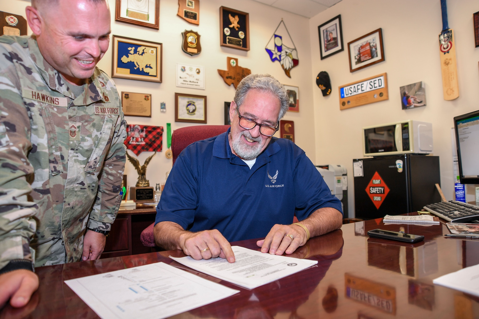 Ballard retires with more than 45 years of service. Photo of Ballard and Hawkins discussing a memo.