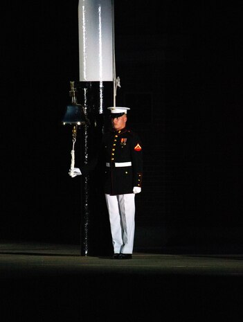 A Barracks Marine strikes the bell signaling the beginning of the Friday Evening Parade at Marine Barracks Washington, July 16, 2021.