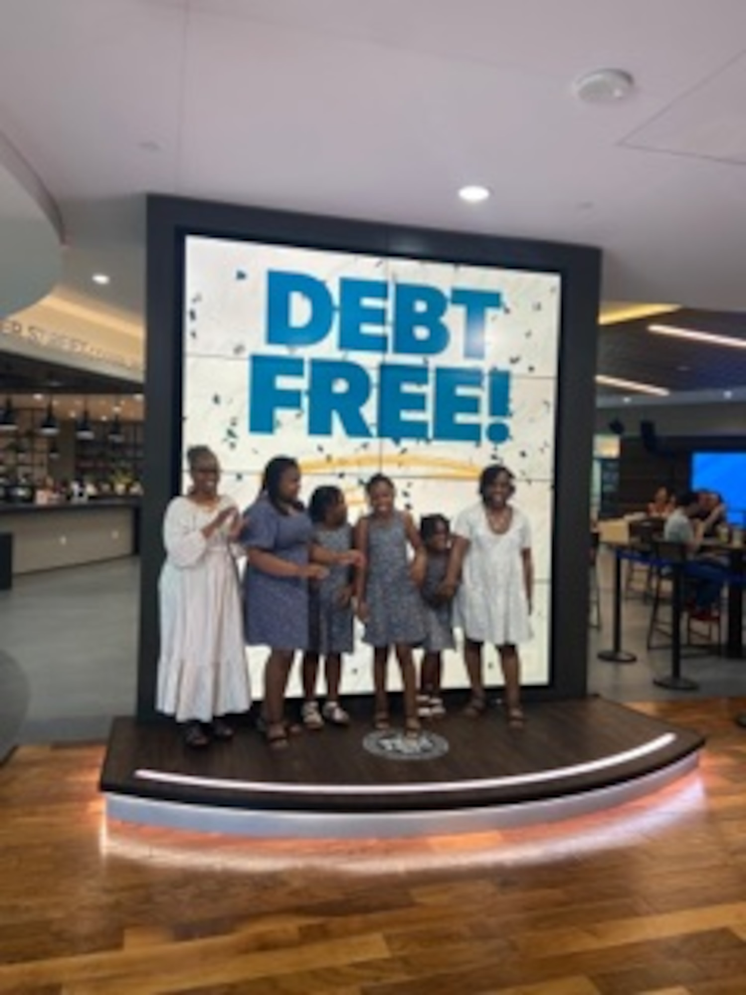 U.S. Air Force Master Sgt. Traci Coston stands next to her family on The Ramsey Show set, May 28, 2021. Coston appeared on the show to explain how she paid off $36,000 in student loan and credit card debt in 14 months. She currently serves as the 9th Air Force (Air Forces Central)/Financial Management superintendent and also holds a financial coaching master’s certification in personal finance to help others achieve their financial dreams.