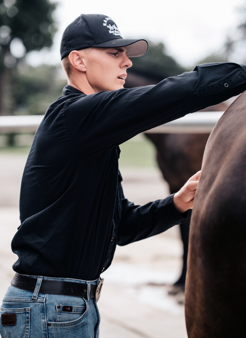 Army Sgt. Jake Walker, a member of the U.S. Army North Caisson Platoon, grooms one of the platoon’s horses