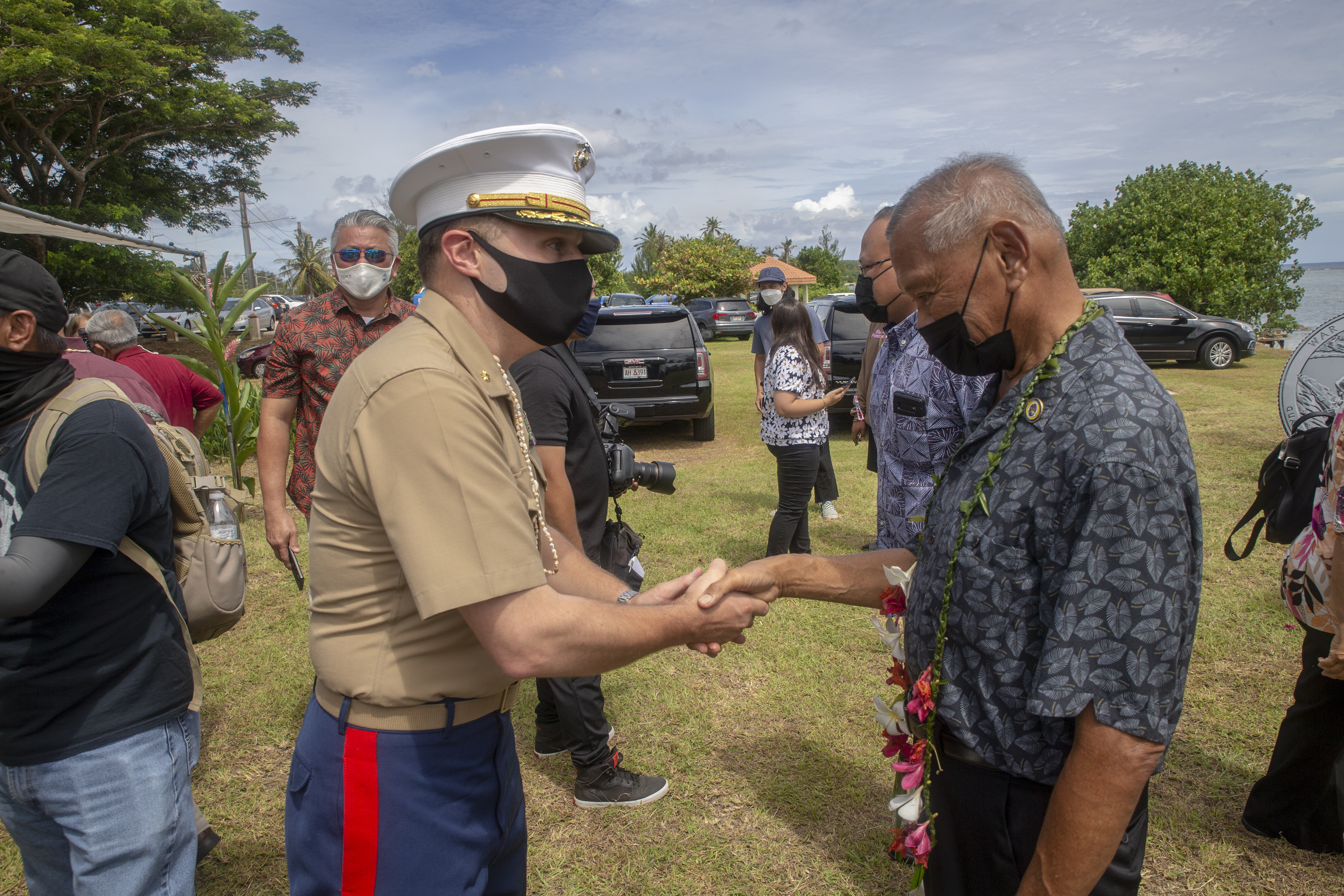 Maj. Colter Bahlau, the Marine Corps Base (MCB) Camp Blaz Operations Officer, greets a World War II survivor during a memorial service at the Asan Memorial Beach Park in Asan, Guam, July 16, 2021.