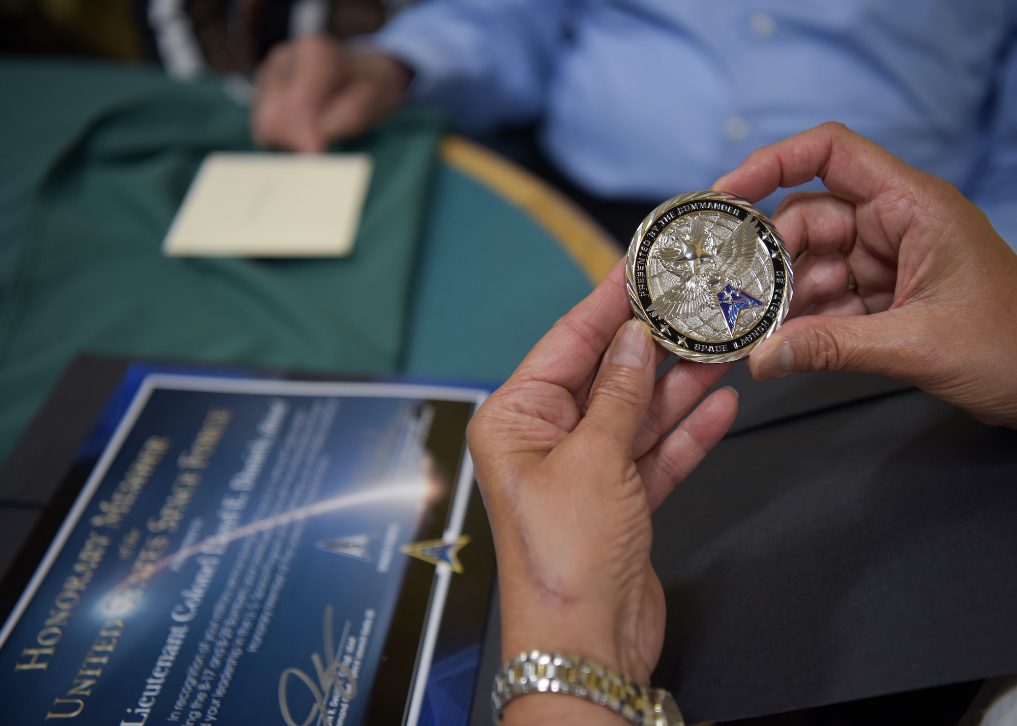 Family members admire the coin and certificate presented to Lt. Col. Lloyd Daniels, retired Air Force veteran, at his 100th birthday celebration in Orcutt, California, July 16, 2021. Daniels received a coin and an “Honorary Member of the United States Space Force” certificate from Col. Robert Long, Space Launch Delta 30 commander. (U.S. Space Force photo by Airman Kadielle Shaw)