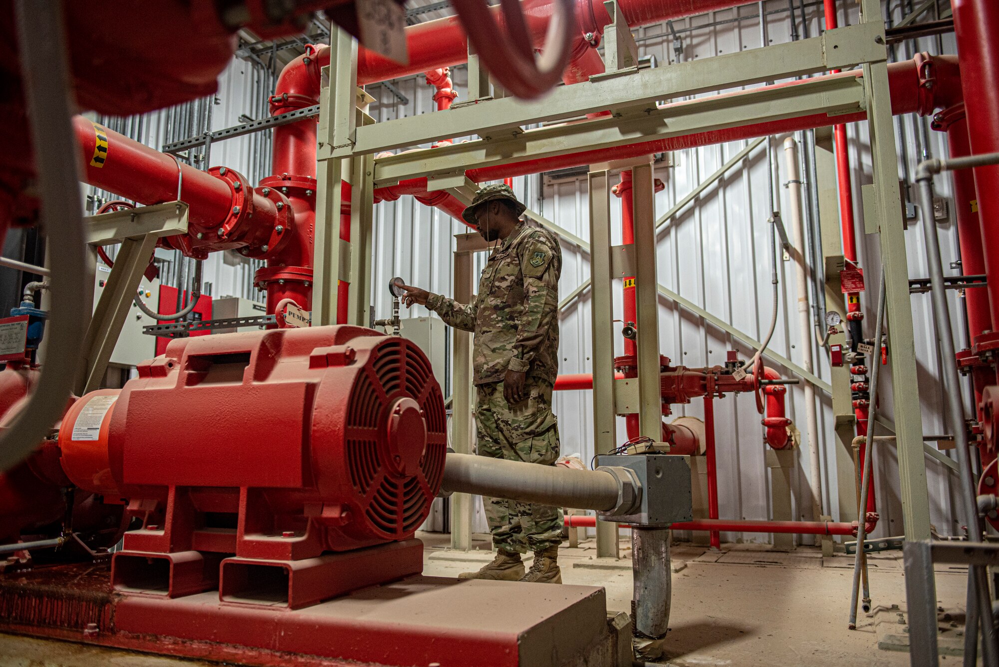 Airman 1st Class Brandon Johnson, 379th Expeditionary Civil Engineer Squadron water and fuel systems maintenance journeyman, checks the pressure gauge on a water storage tank June 16, 2021 at Al Udeid Air Base, Qatar.