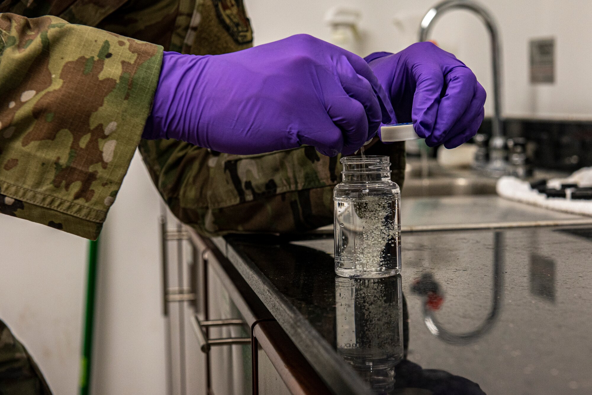 Senior Airman Matthew Ketterling, 379th Expeditionary Medical Operations Squadron bioenvironmental engineering journeyman, pours Colisure into a water sample to ensure that it is consumable June 16, 2021, at Al Udeid Air Base, Qatar.
