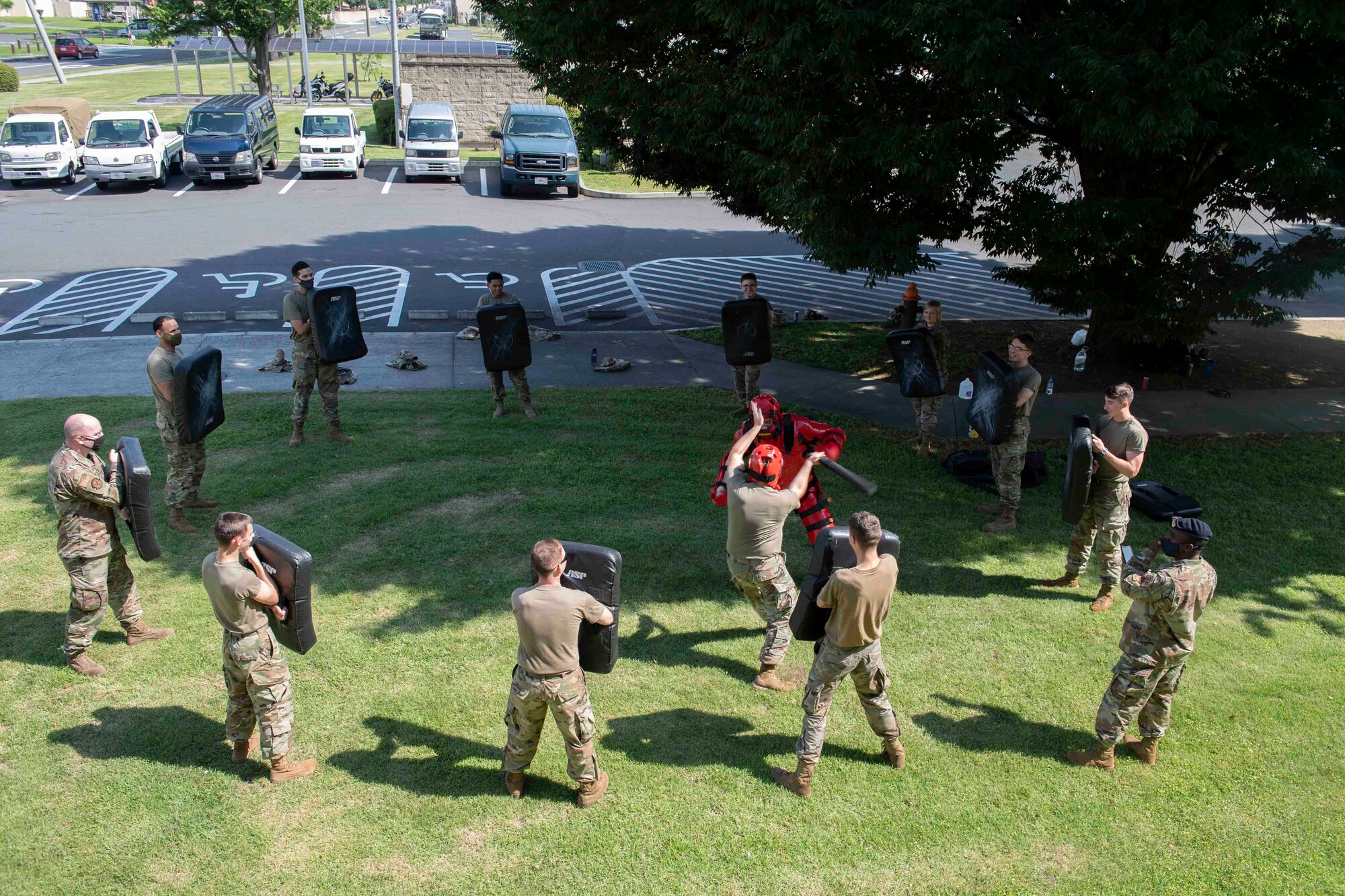 Airmen from the 374th Mission Support Group take turns fighting Senior Airman Tyler Gutierrez, 374th Security Forces Squadron training instructor, during a 374th MSG training day at Yokota Air Base, Japan, July 21, 2021.