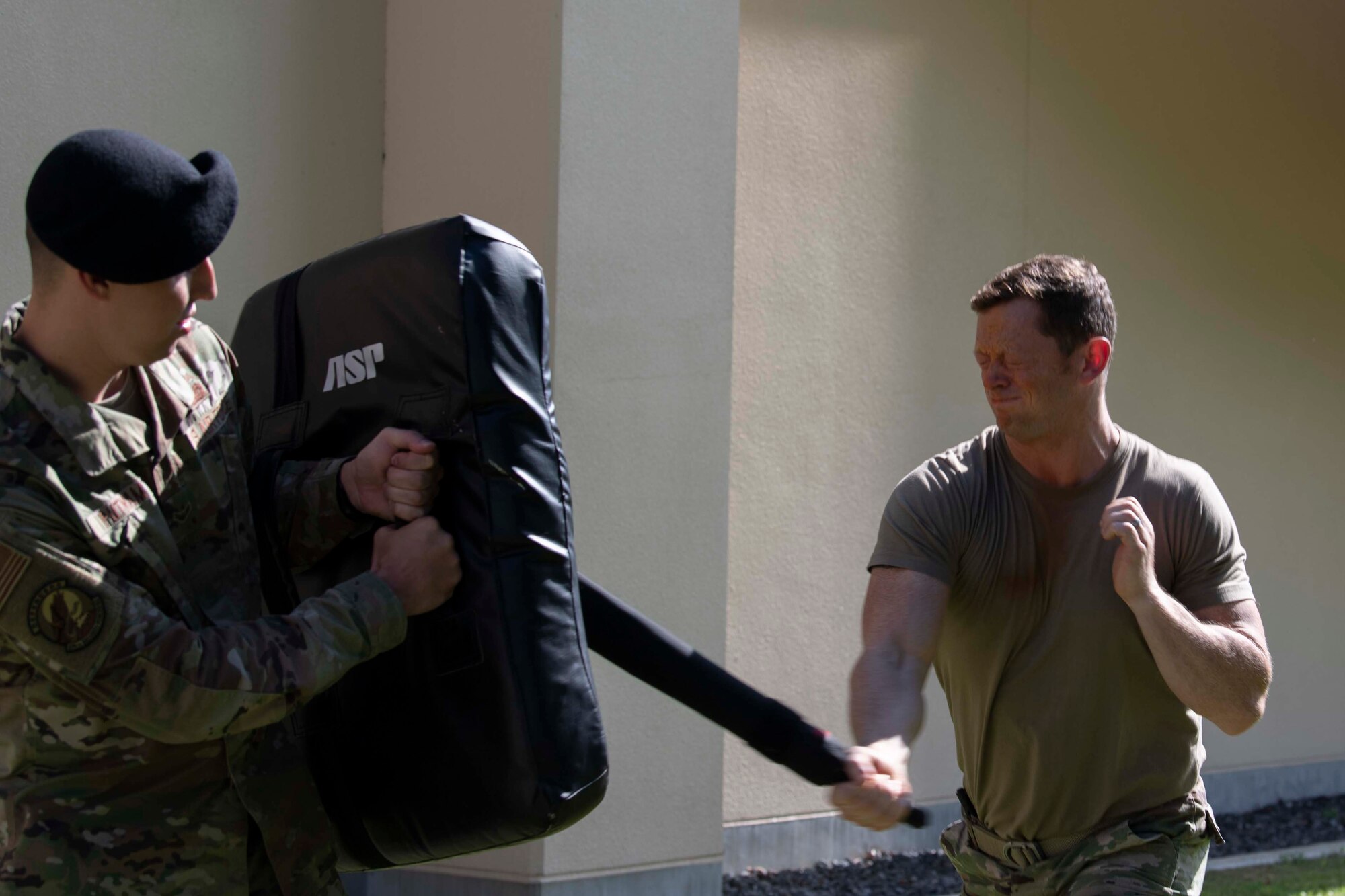 Maj. Matthew Stillman, 374th Security Forces Squadron commander, strikes a pad with a baton after being sprayed with oleoresin capsicum spray during a 374th Mission Support Group training day at Yokota Air Base, Japan, July 21, 2021.