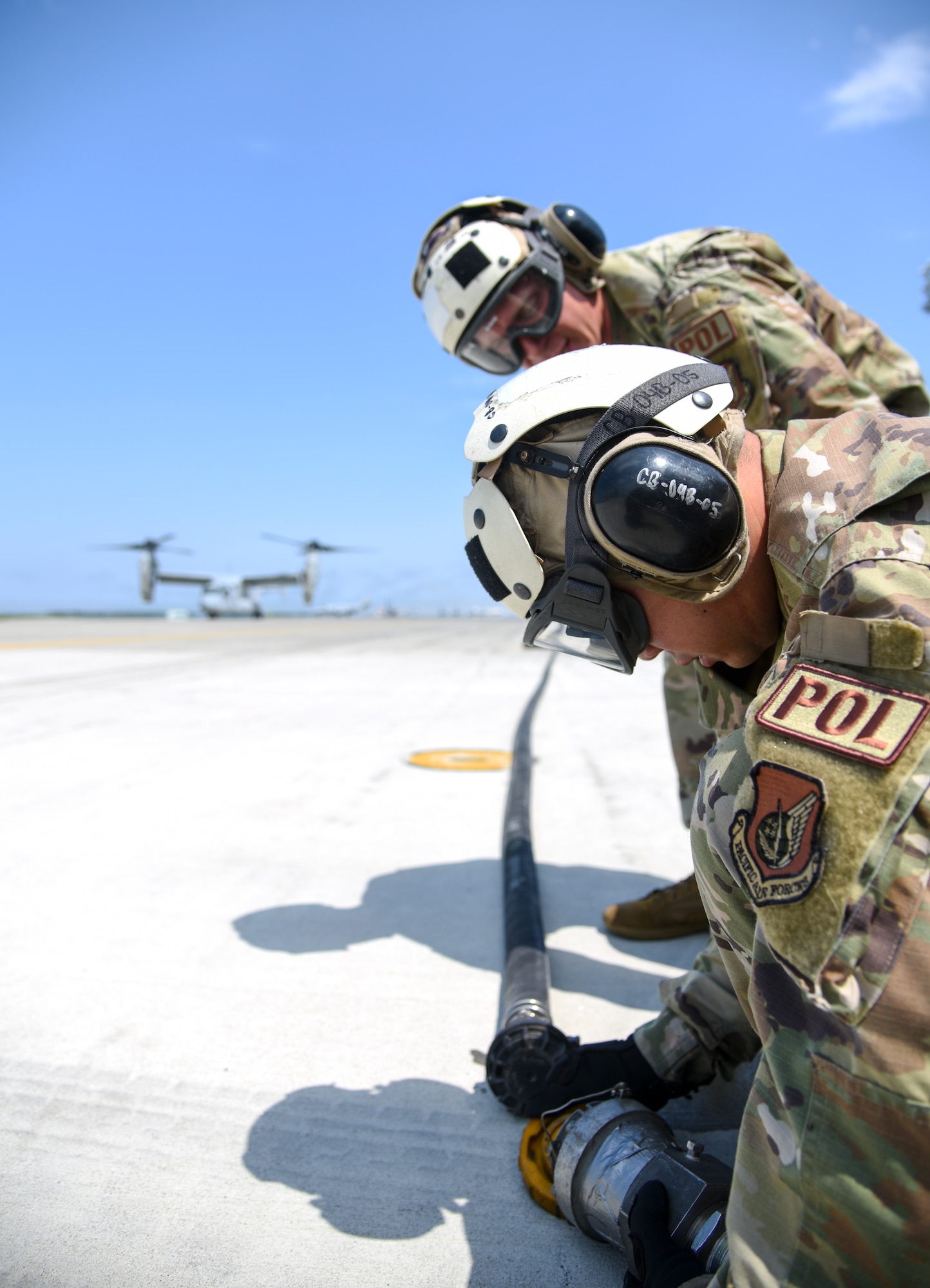 Two Airmen remove the coupling on a fuel hose.