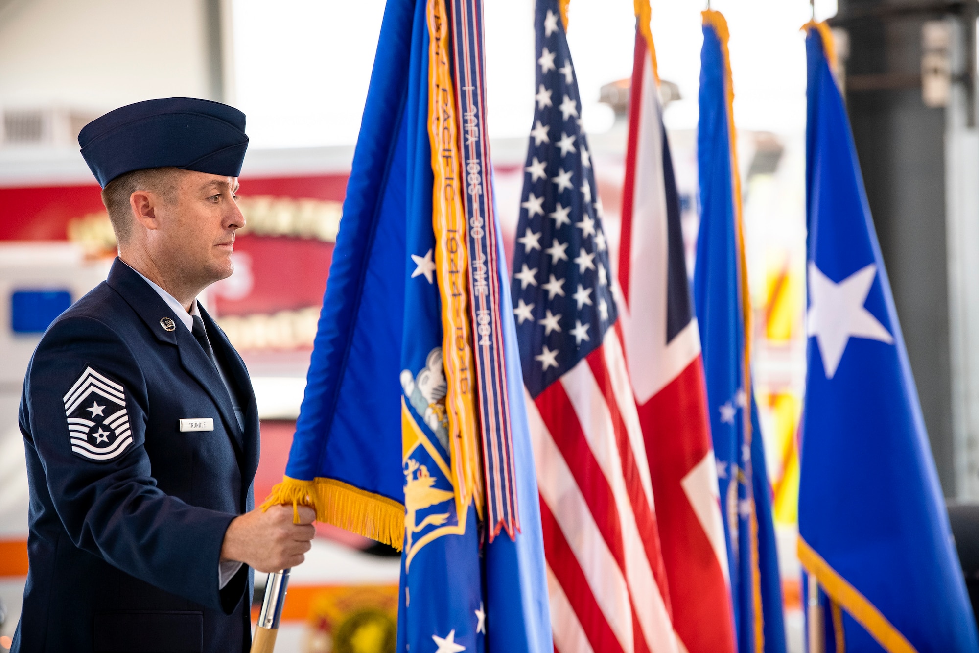 U.S. Air Force Chief Master Sgt. Joshua Trundle, 501st Combat Support Wing command chief, holds the guidon during a change of command ceremony at RAF Alconbury, England, July 20, 2021. The ceremony is a military tradition that represents a formal transfer of a unit’s authority and responsibility from one commander to another. (U.S. Air Force photo by Senior Airman Eugene Oliver)