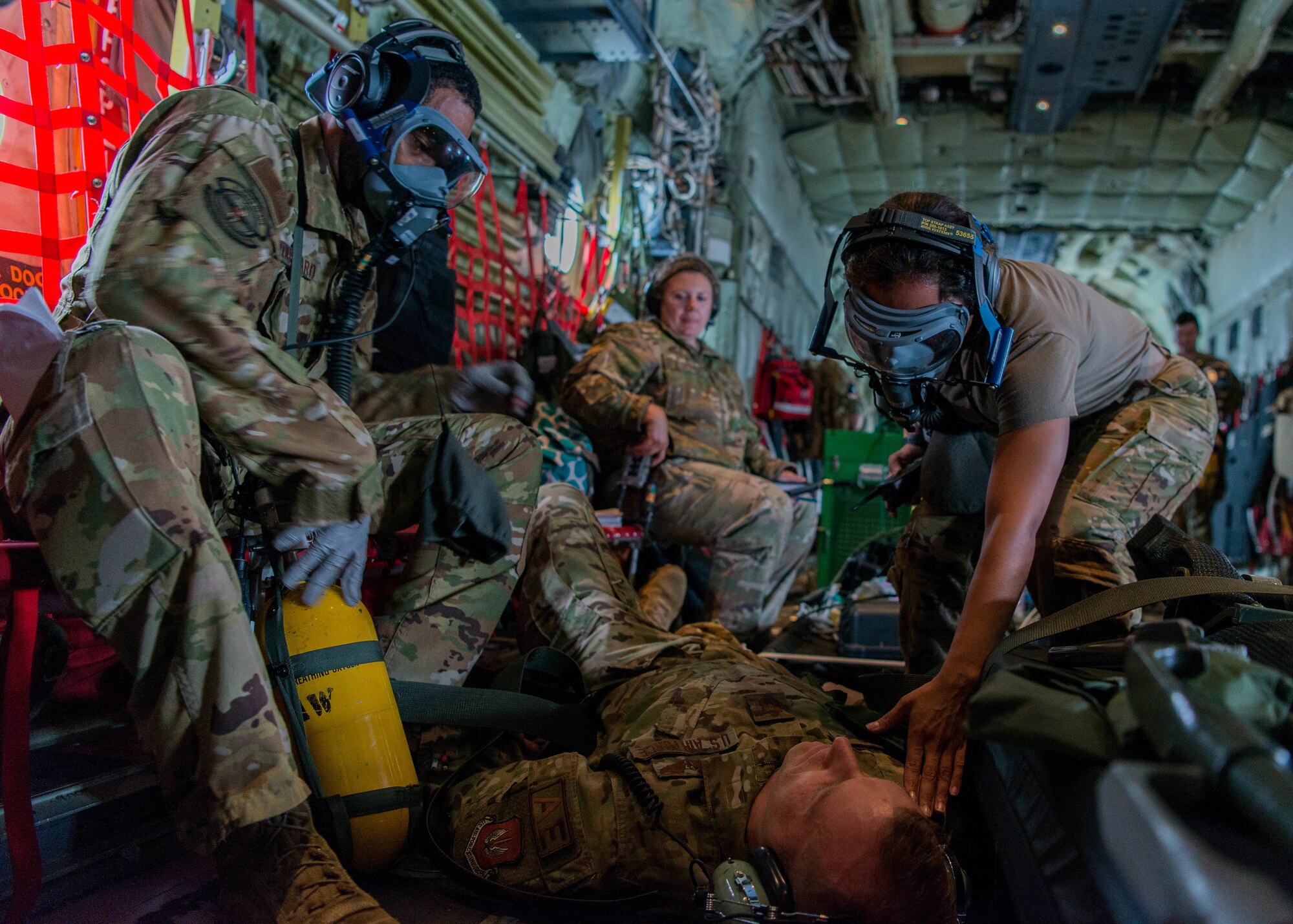 U.S. Air Force medical personnel secure a patient during a simulated fire