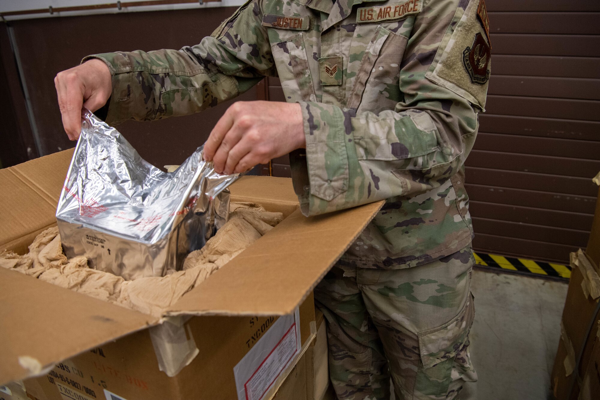 Airman pulling bag out of box