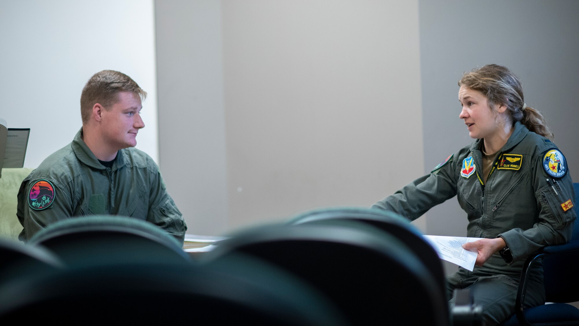 Two people sit across from each other in a room