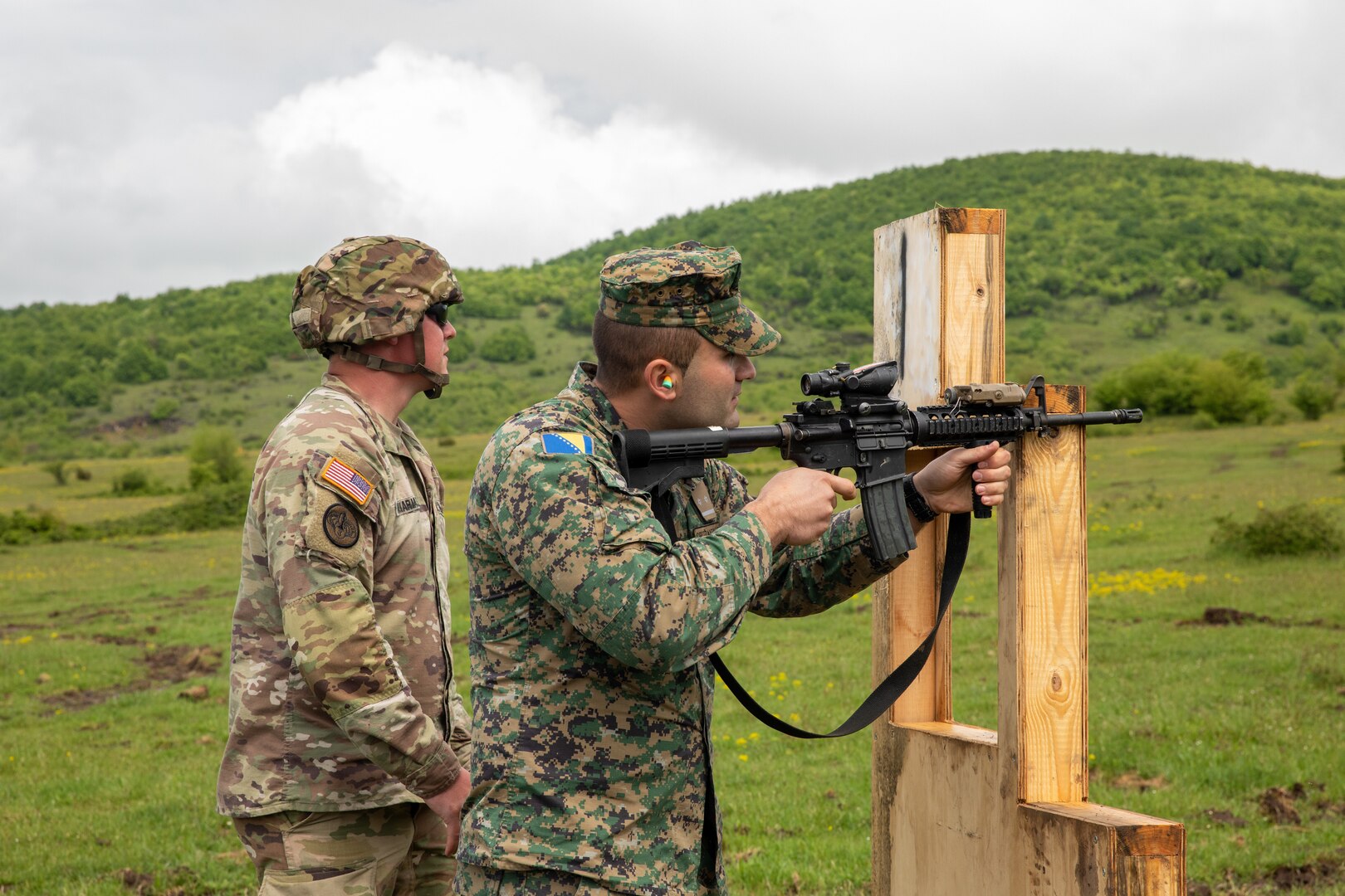 U.S. Army Staff Sgt. Justin Sachariason, left, a Soldier assigned to the Florida Army National Guard's 2nd Battalion, 124th Infantry Regiment, 53rd Infantry Brigade Combat Team, instructs 1st Lt. Almir Sarac, a soldier with the Armed Forces of Bosnia and Herzegovina, how to shoot the M4A1 carbine rifle at Manjaca Training Area, Bosnia and Herzegovina, May 19, 2021.