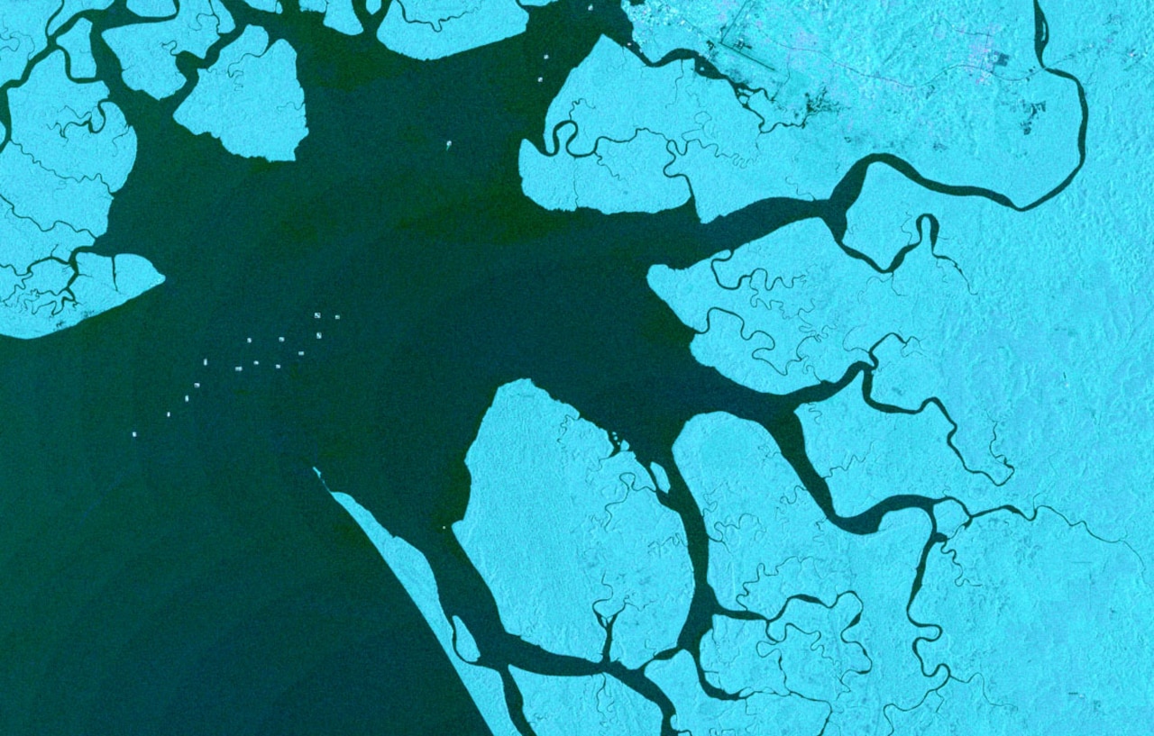 A satellite photo of a waterway indicates vessel location with dots.