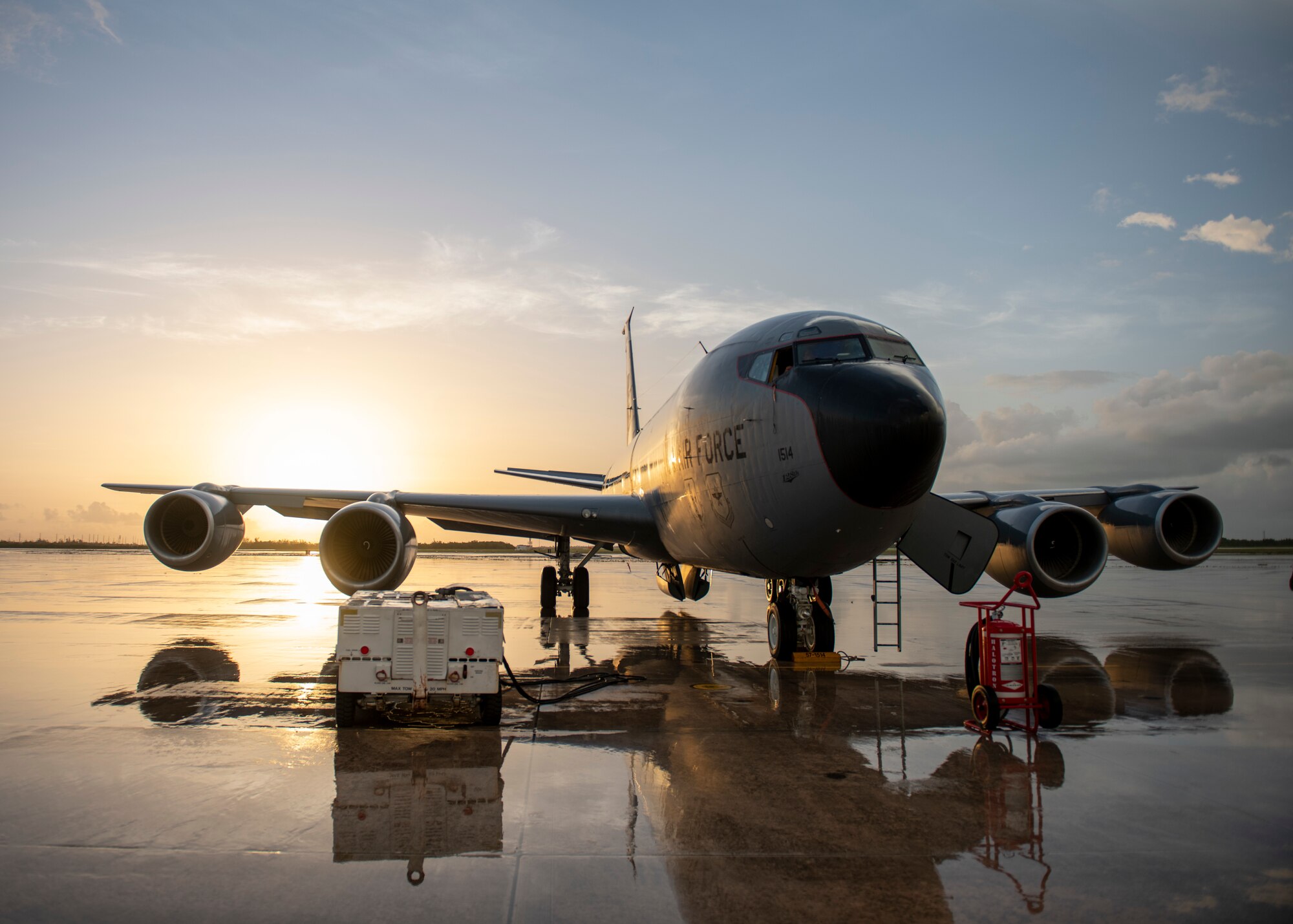 A tanker aircraft sits on the flight line during sunrise