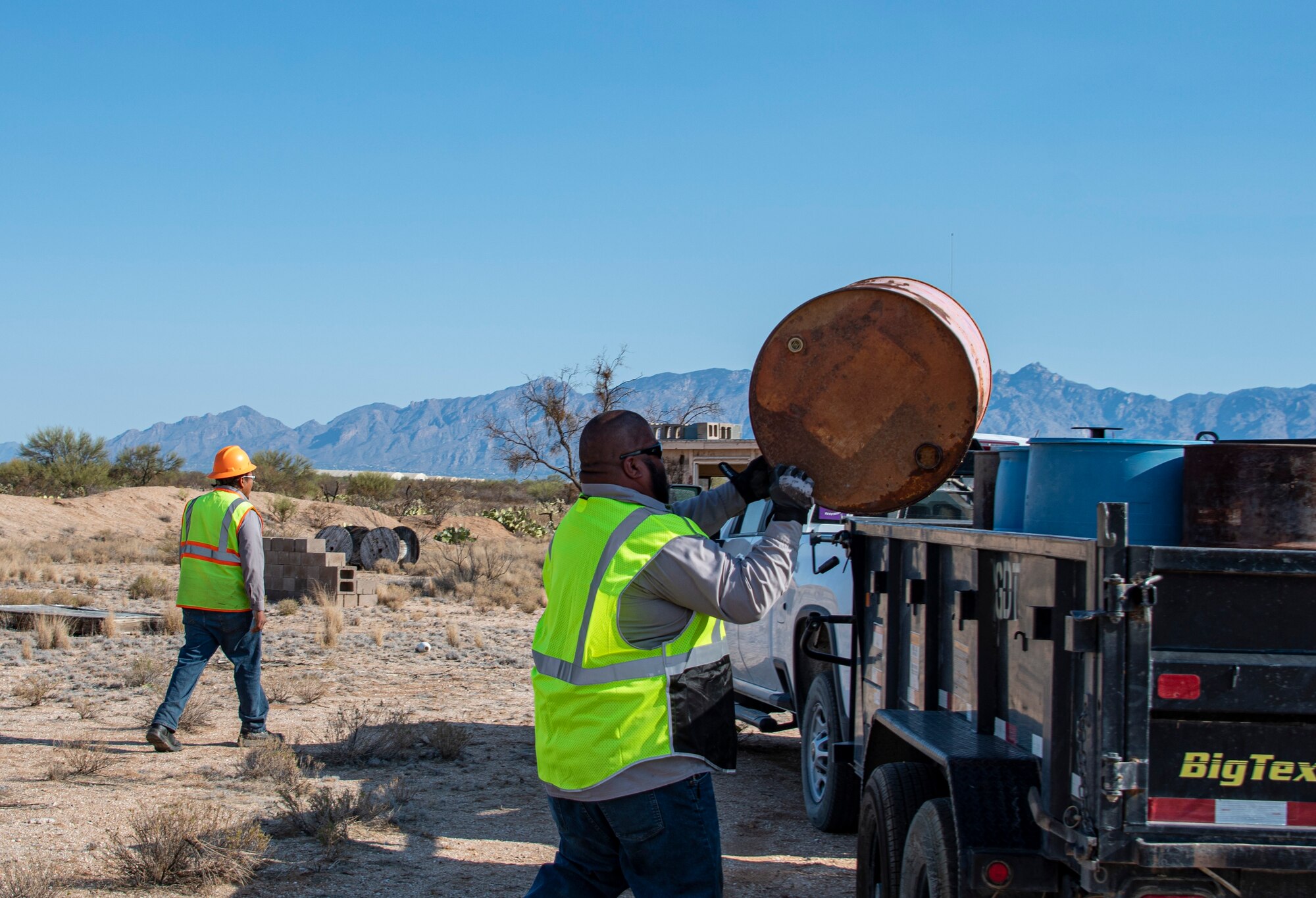 People loading drums into truck.
