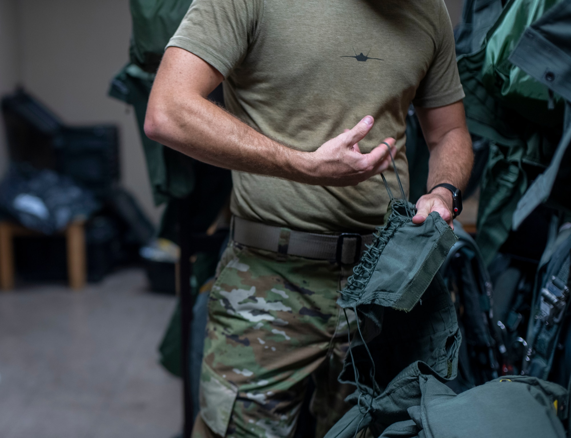 A man laces up a flight suit