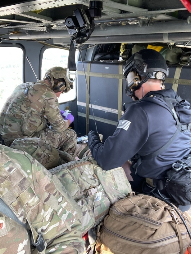 Guardian Angel team of the 212th Rescue Squadron, 176th Wing, Alaska Air National Guard, stabilizes and provides airborne medical care for a U.S. Army Alaska paratrooper during medevac July 14, 2021. The Soldier sustained injuries in a routine static-line jump over Malamute Drop Zone on Joint Base Elmendorf-Richardson. (Alaska Air National Guard photo by Master Sgt. Andre Marron/Released)