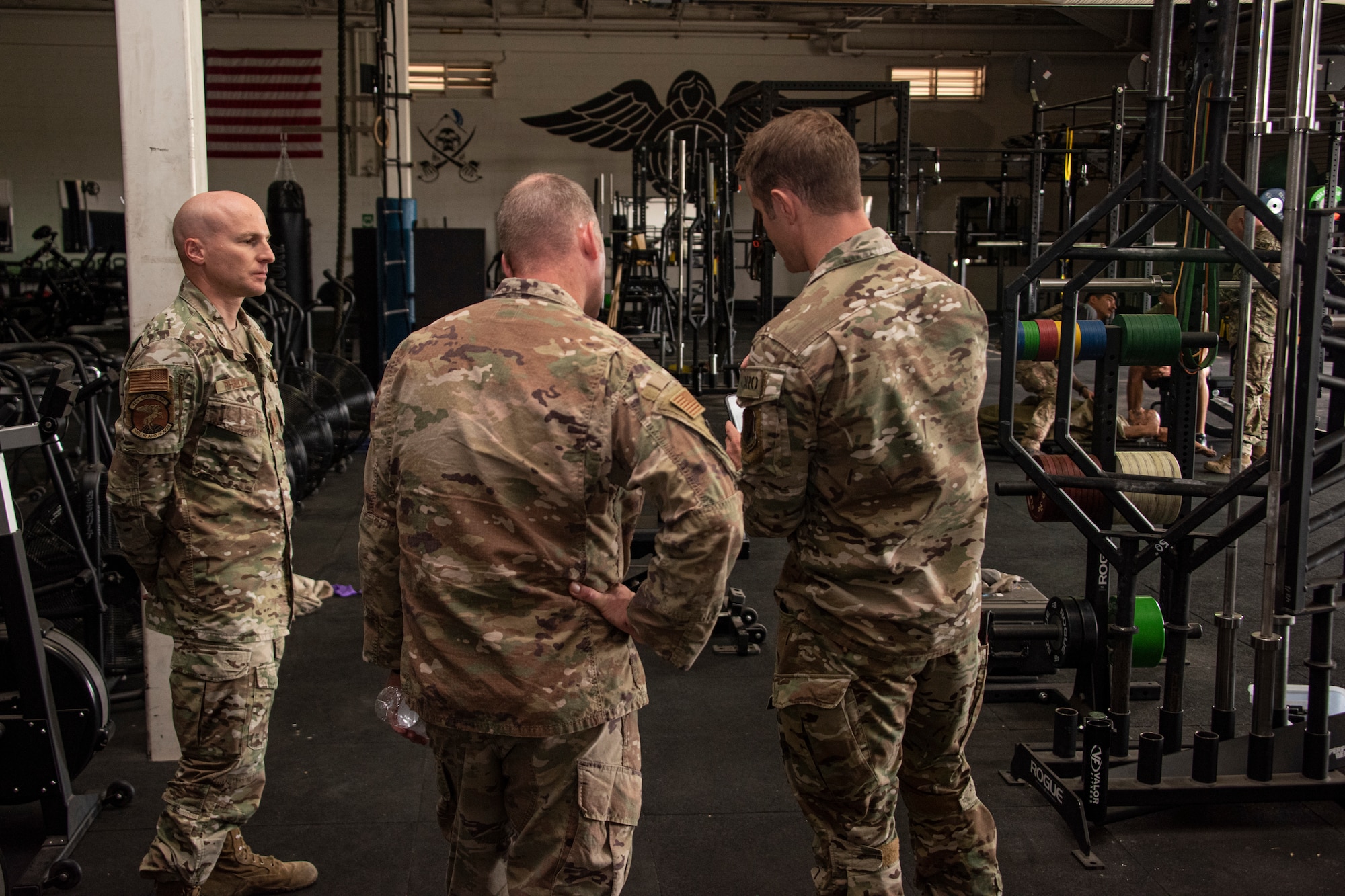 A photo of Airmen talking in a gym.
