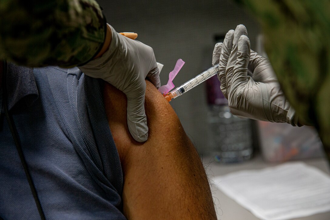 A Master Labor Contractor with Marine Corps Installations Pacific receives the second dose of the COVID-19 vaccine at the U.S. Naval Hospital Okinawa on Camp Foster, Okinawa, Japan, July 16, 2021. Vaccinating host nation employees will contribute to the prevention of further spread of COVID-19 in Japan and will protect the resilience of the alliance. (U.S. Marine Corps photo by Lance Cpl. Alex Fairchild)