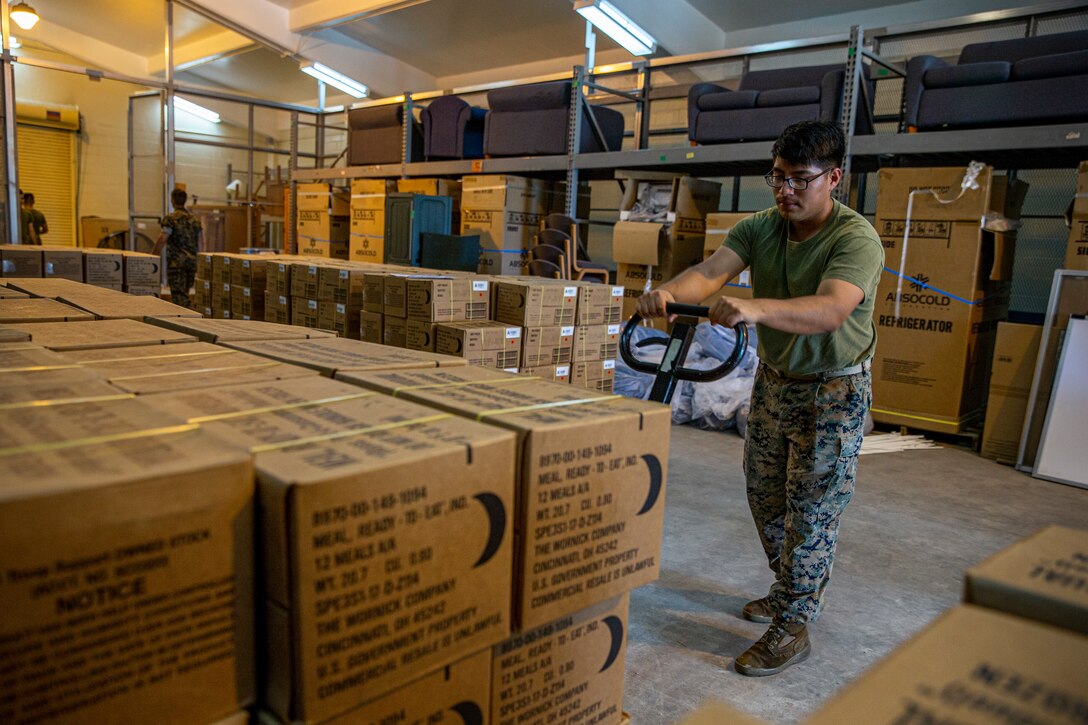 U.S. Marine Corps Lance Cpl. Edwin Carino, a distribution management specialist with Headquarters and Support Battalion, Marine Corps Installations Pacific, transports meals, ready to eat (MRE’s) on Camp Lester, Okinawa, Japan, July 19, 2021. In preparation for Typhoon In-Fa, Camp Foster Camp Services provide units with MRE’s, base preparation services, sandbags, and bulk trash storage to keep service members safe and prepared during typhoon season in Okinawa. Carino is a native of Rariden, New Jersey. (U.S. Marine Corps photo by Lance Cpl. Alex Fairchild)