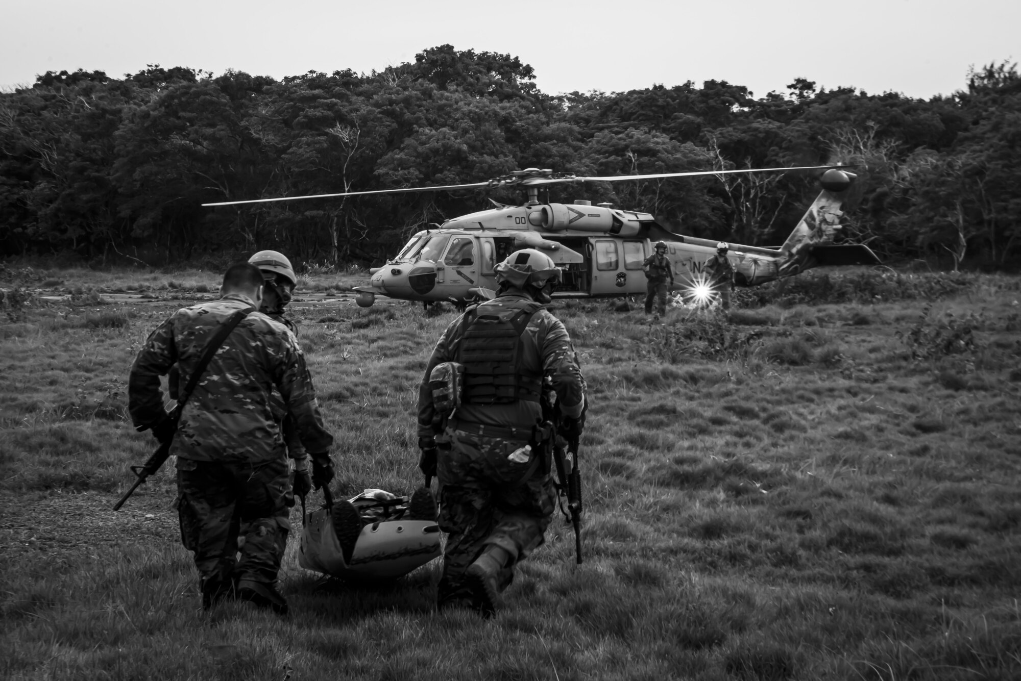 U.S. Air Force Airmen assigned to the 154th Fighter Wing, Hawaii Air National Guard carry a “fallen comrade” in a litter to a U.S. Navy Helicopter Sea Combat Squadron 25 helicopter as part of combat readiness training course during Operation Pacific Iron 2021, July 20, 2021, at Andersen Air Force Base, Guam.