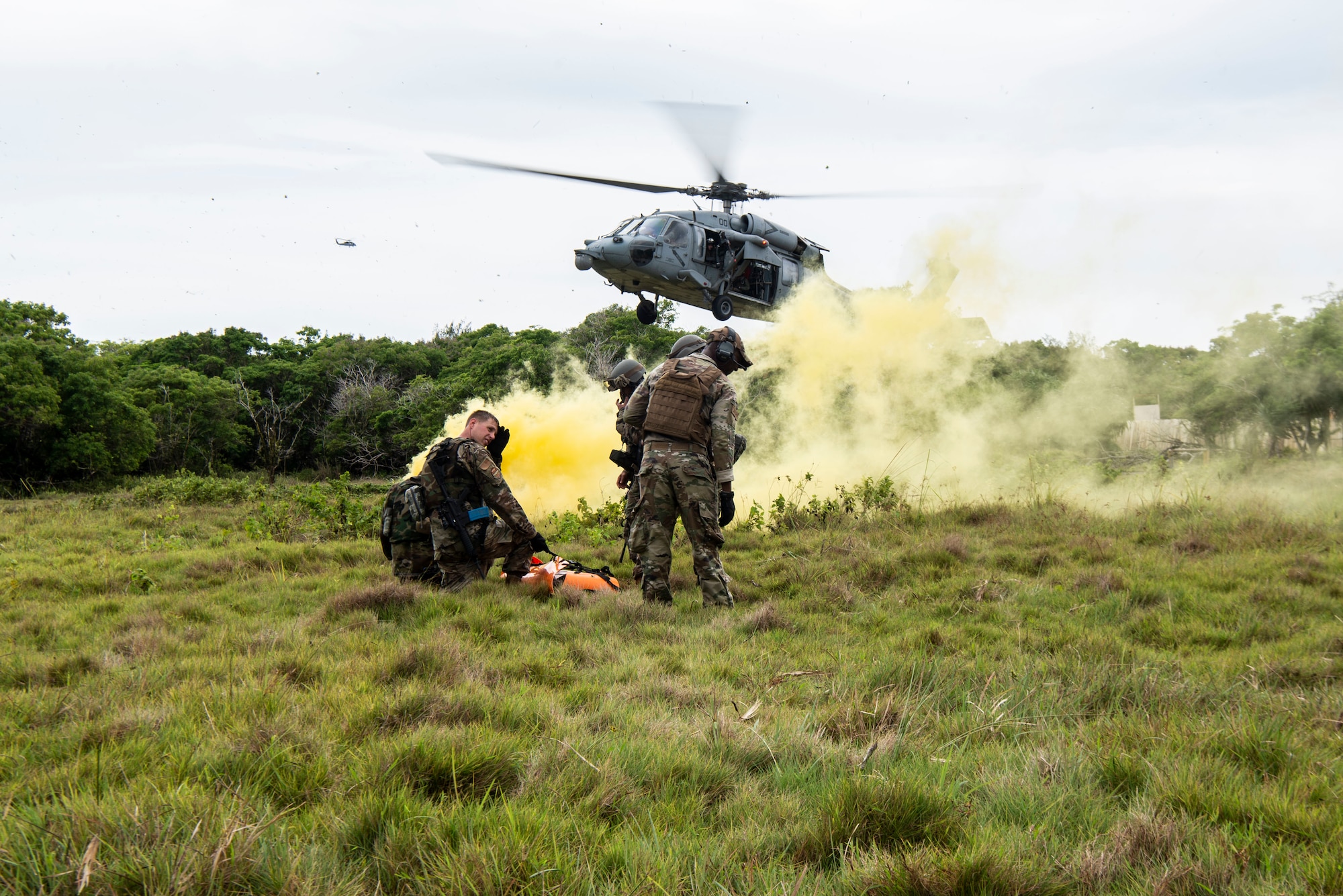 U.S. Air Force Airmen assigned to the 154th Fighter Wing, Hawaii Air National Guard wait with a “fallen comrade” in a litter to practice medical evacuation with U.S. Navy Helicopter Sea Combat Squadron 25 as part of a combat readiness training course during Operation Pacific Iron 2021, July 20, 2021, at Andersen Air Force Base, Guam.
