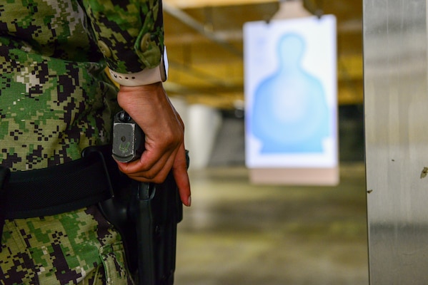 A Sailor assigned to Navy Reserve Naval Security Forces Fort Worth draws her service pistol in preparation to fire at a target during a weapons qualification exercise held at the small arms range aboard Naval Air Station Fort Worth Joint Reserve Base. The exercise is part of a  Navy-wide sustainment training requirement for all Sailors designated as armed watch standers. (U.S. Navy photo by Mass Communication Specialist 1st Class Lawrence Davis)