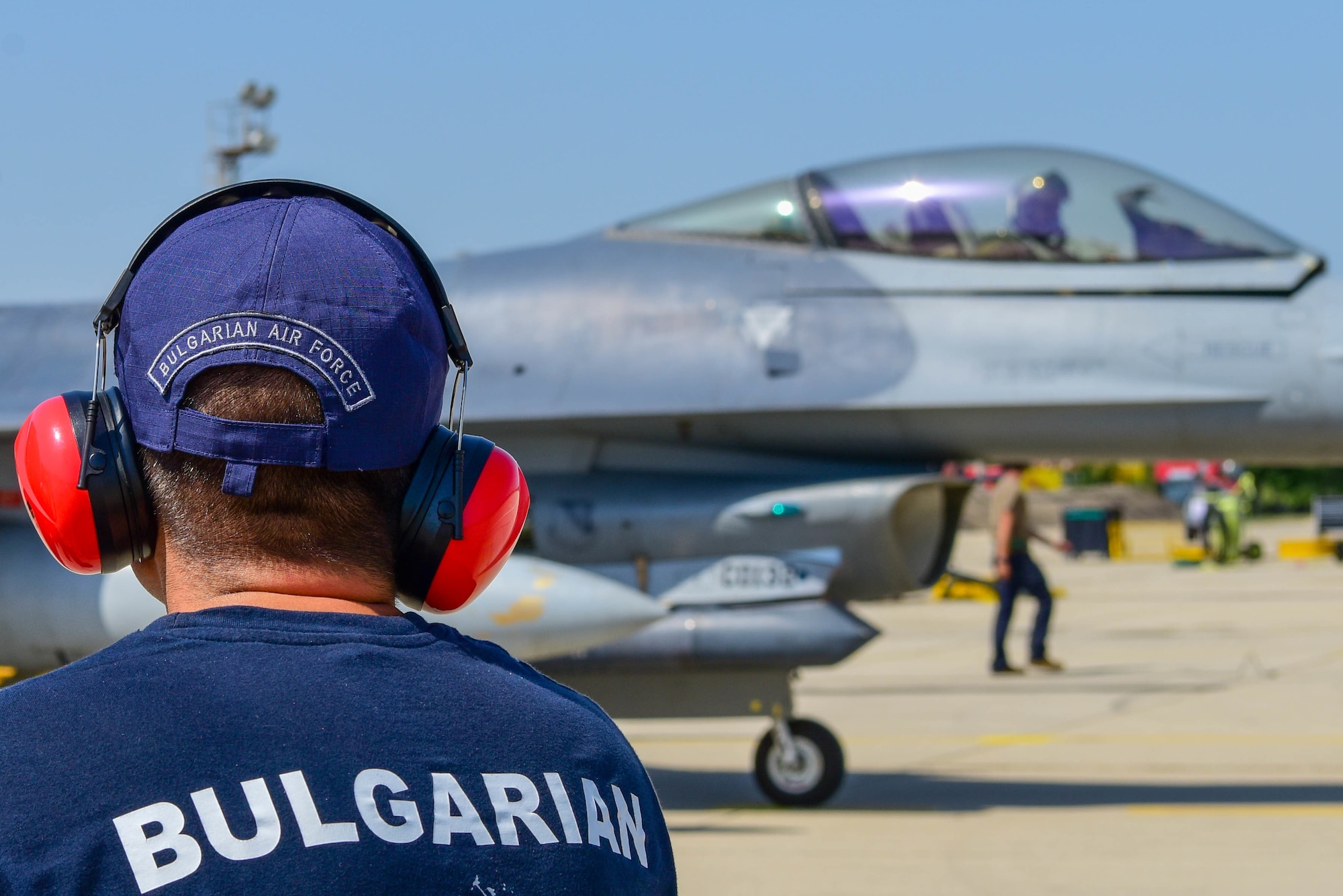 A Bulgarian air force member looks at a U.S. Air Force F-16 Fighting Falcon assigned to the 555th Fighter Squadron during exercise Thracian Star 21 at Graf Ignatievo Air Base, Bulgaria, July 16, 2021. Thracian Star 21 is a Bulgarian air force-led exercise aiming to enhance interoperability and the ability to rapidly deploy to remote locations. (U.S. Air Force photo by Airman 1st Class Brooke Moeder)