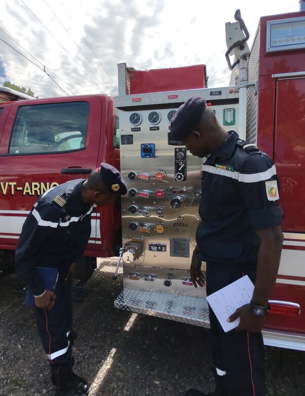 Two members of Senegal's National Fire Brigade examine a Vermont National Guard fire response vehicle July 12, 2021, at Camp Johnson, Vermont National Guard Joint Force Headquarters in Colchester. Delegates from Senegal’s fire brigade visited Vermont as part of the National Guard’s State Partnership Program.