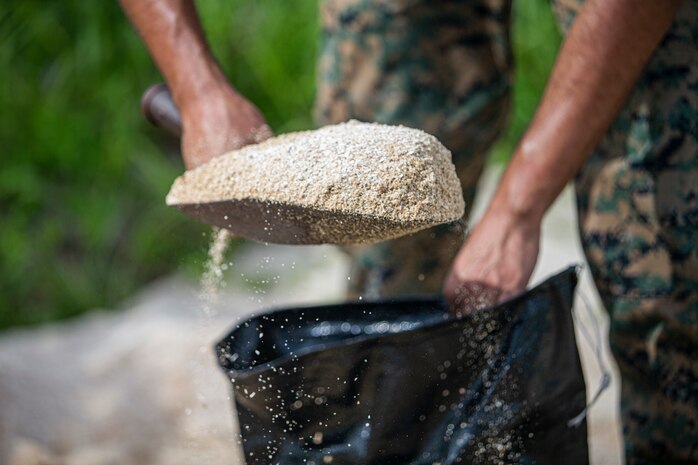 U.S. Marine Corps Pfc. Victor Magana, a motor transportation technician with 3d Transportation Battalion, 3d Marine Logistics Group, fills a sandbag on Camp Foster, Okinawa, Japan, July 19, 2021. In preparation for Typhoon In-Fa, Camp Foster Camp Services provide units with MRE’s, base preparation services, sandbags, and bulk trash storage to keep service members safe and prepared during typhoon season in Okinawa. Magana is a native of Santa Paula, California. (U.S. Marine Corps photo by Lance Cpl. Alex Fairchild)