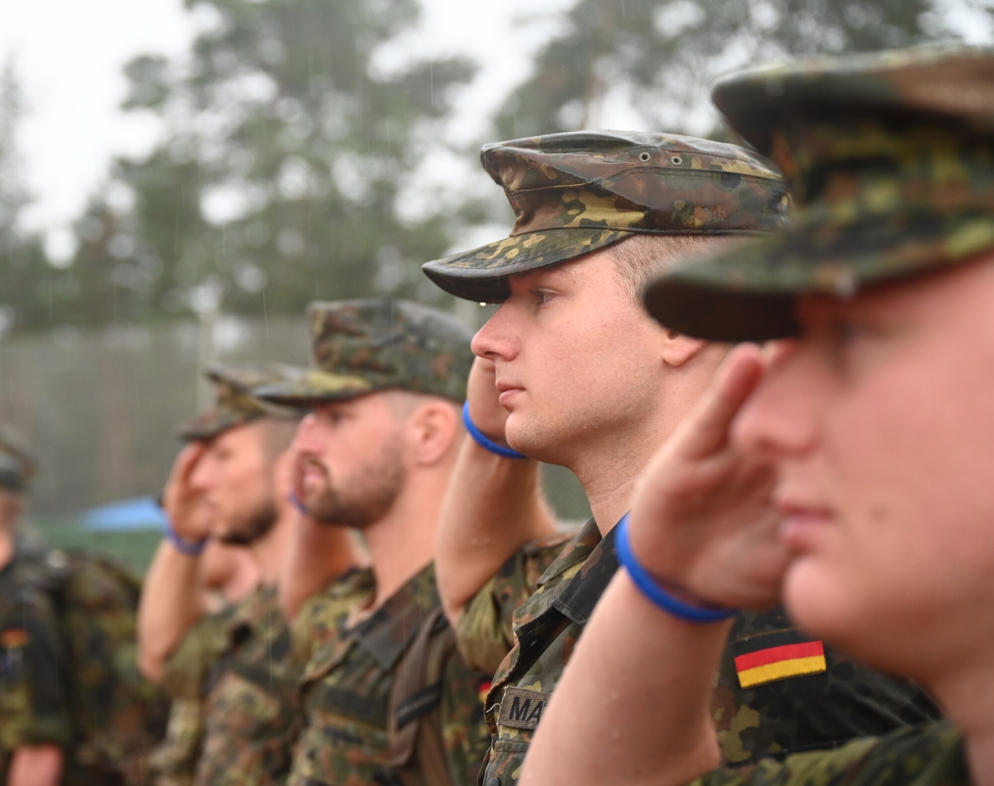 German Air Force Academy cadets salute during the German national anthem at Ramstein Air Base, Germany, July 16, 2021. The cadets participated in the 6th Annual Chief Master Sgt. of the Air Force Paul Airey Memorial Ruck while at Ramstein for a two week internship with the 86th Maintenance Squadron to learn about aircraft and how they function. (U.S. Air Force photo by Senior Airman Thomas Karol)