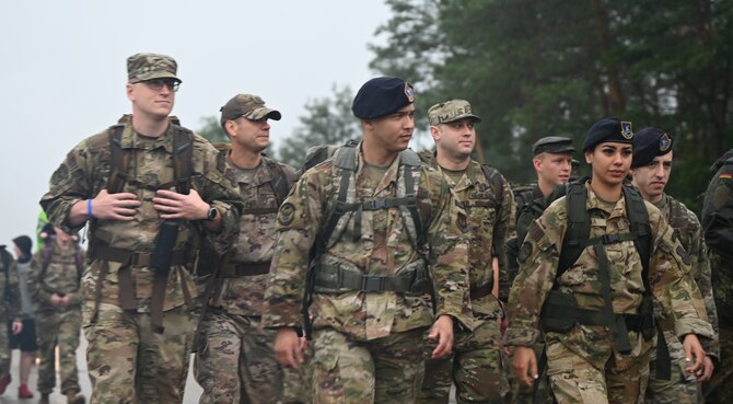 U.S. Air Force Airmen assigned to the 786th Explosive Ordnance Disposal Flight, hold up a flag during the 6th Annual Chief Master Sgt. Of the Air Force Paul Airey Memorial Ruck at Ramstein Air Base, Germany, July 16, 2021. More than 100 Airmen, civilians and family members participated in the ruck to remember Airey for his resiliency during his time as a Prisoner of War and his dedication to the Airmen of the U.S. Air Force. (U.S. Air Force photo by Senior Airman Thomas Karol)