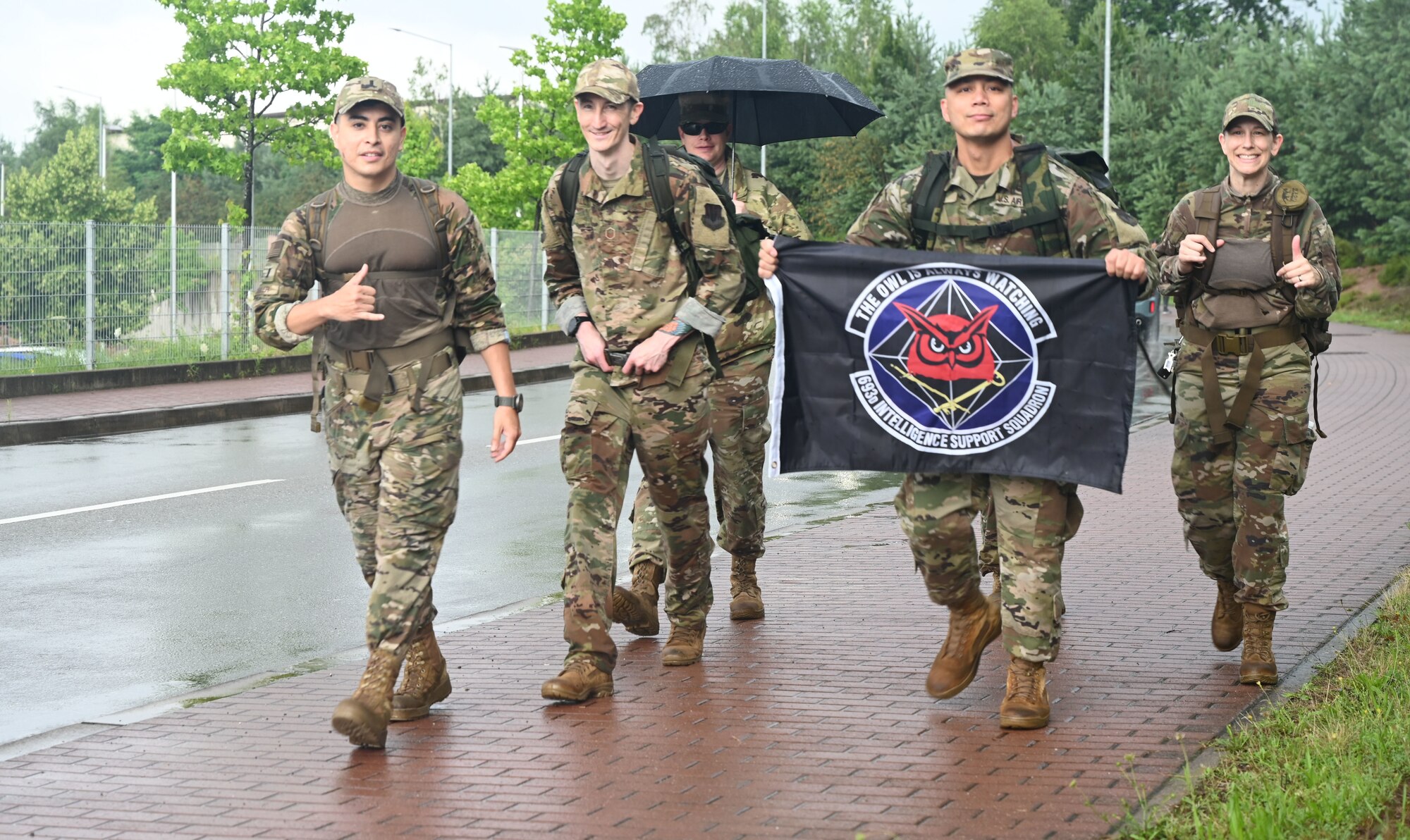 U.S. Air Force Airmen, assigned to the 693rd Intelligence Support Squadron, hold a banner during the 6th Annual Chief Master Sgt. Of the Air Force Paul Airey Memorial Ruck at Ramstein Air Base, Germany, July 16, 2021. Airey flew with the 485th Bombardment Group During World War II and was captured after being shot down and spent the rest of the conflict as a prisoner of war. (U.S. Air Force photo by Senior Airman Thomas Karol)
