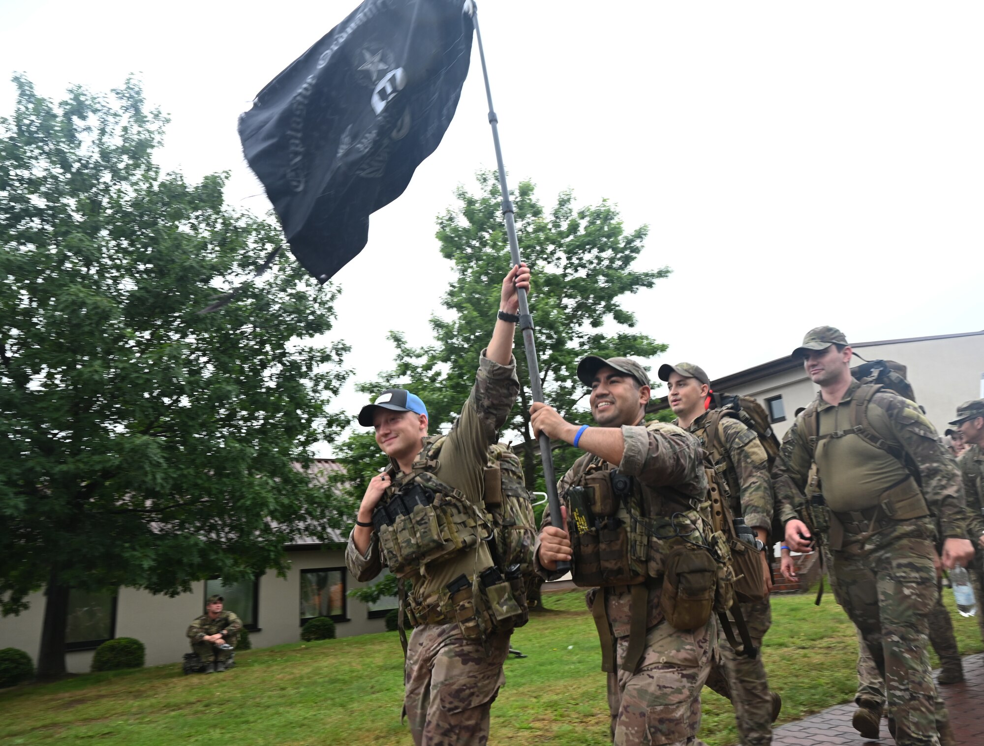 U.S. Air Force Airmen assigned to the 786th Explosive Ordnance Disposal Flight, hold up a flag during the 6th Annual Chief Master Sgt. Of the Air Force Paul Airey Memorial Ruck at Ramstein Air Base, Germany, July 16, 2021. More than 100 Airmen, civilians and family members participated in the ruck to remember Airey for his resiliency during his time as a Prisoner of War and his dedication to the Airmen of the U.S. Air Force. (U.S. Air Force photo by Senior Airman Thomas Karol)