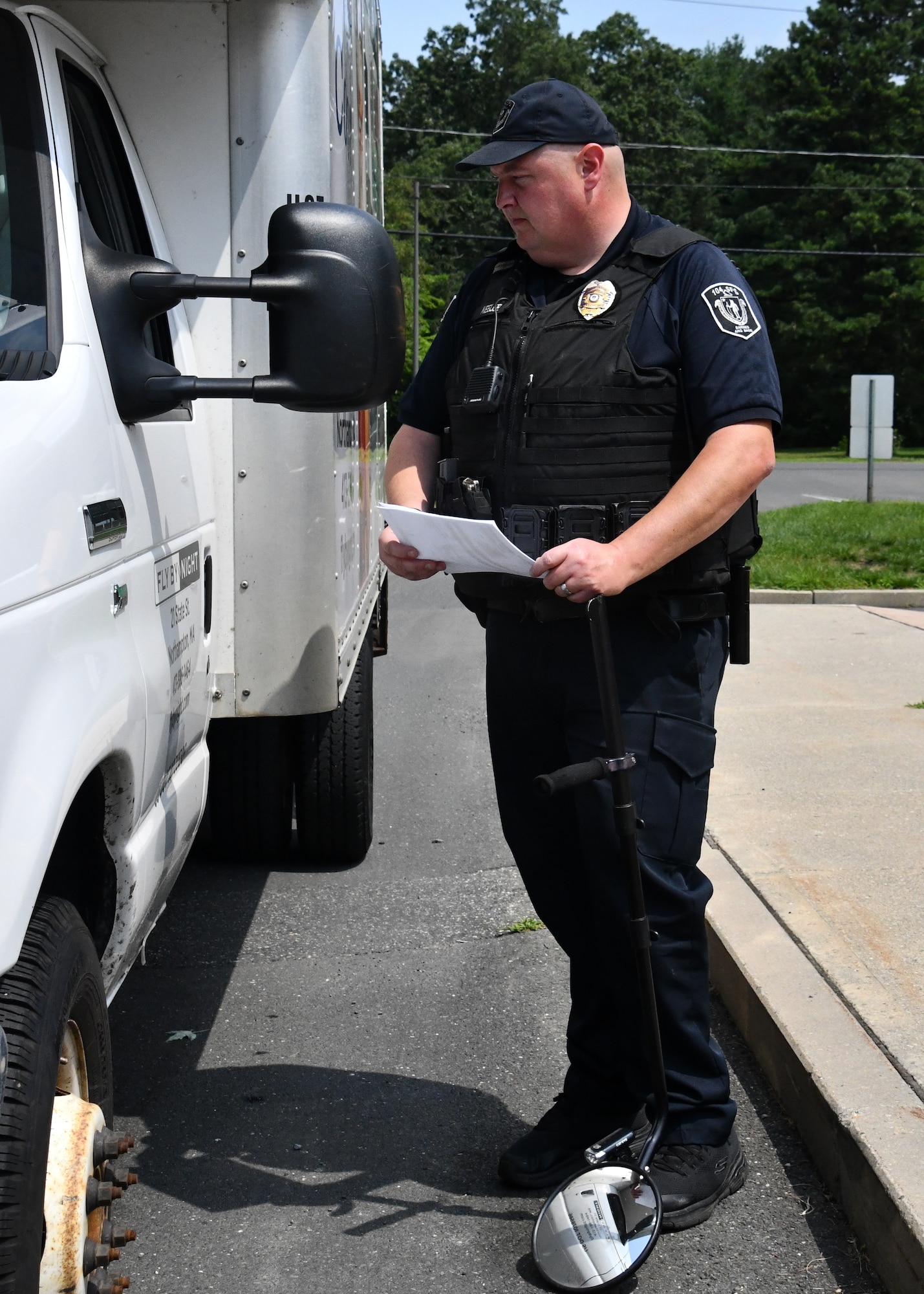 Officer Robert Keeler, 104th Fighter Wing Installation Security Officer, inspects a commercial vehicle looking for contraband July 21, 2021, at Barnes Air National Guard Base, Massachusetts. Keeler works with other civilian officers and military defenders to ensure safety on base.  (U.S. Air National Guard photo by Staff Sgt. Sara Kolinski)