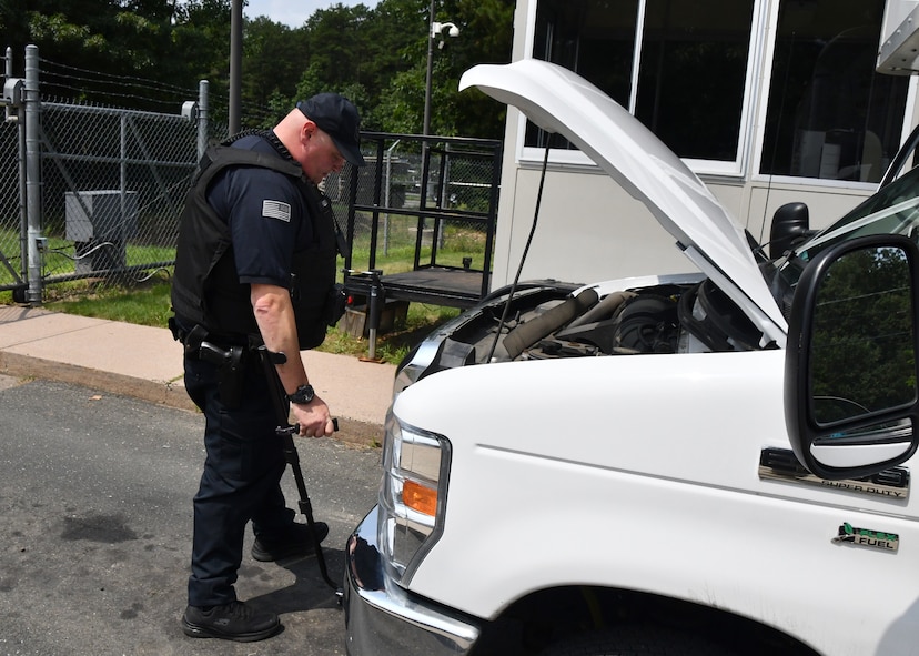 Officer Robert Keeler, 104th Fighter Wing Installation Security Officer, inspects a commercial vehicle looking for contraband July 21, 2021, at Barnes Air National Guard Base, Massachusetts. Keeler works with other civilian officers and military defenders to ensure safety on base.  (U.S. Air National Guard photo by Staff Sgt. Sara Kolinski)