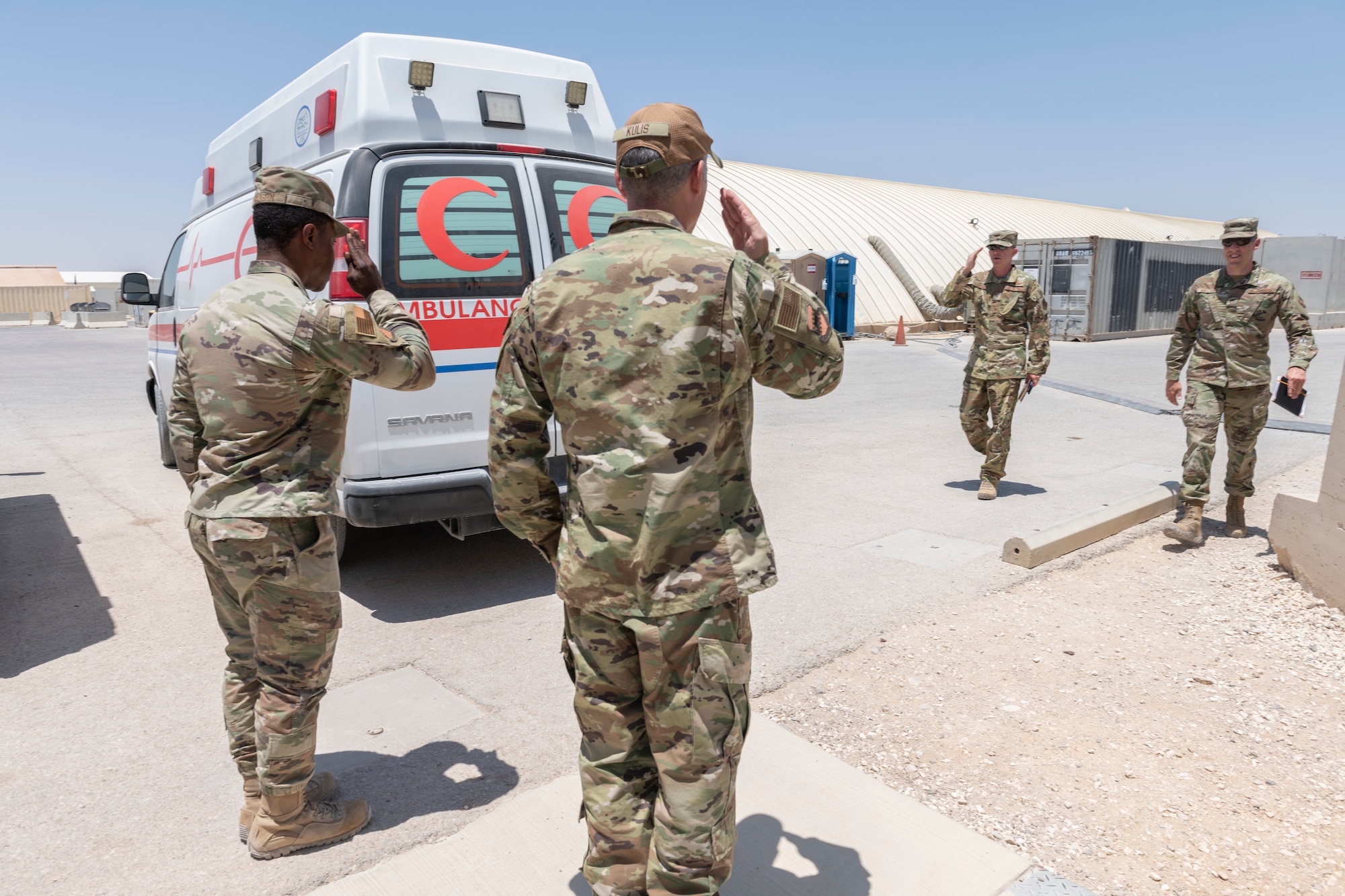 Two U.S. Airmen salute their commander