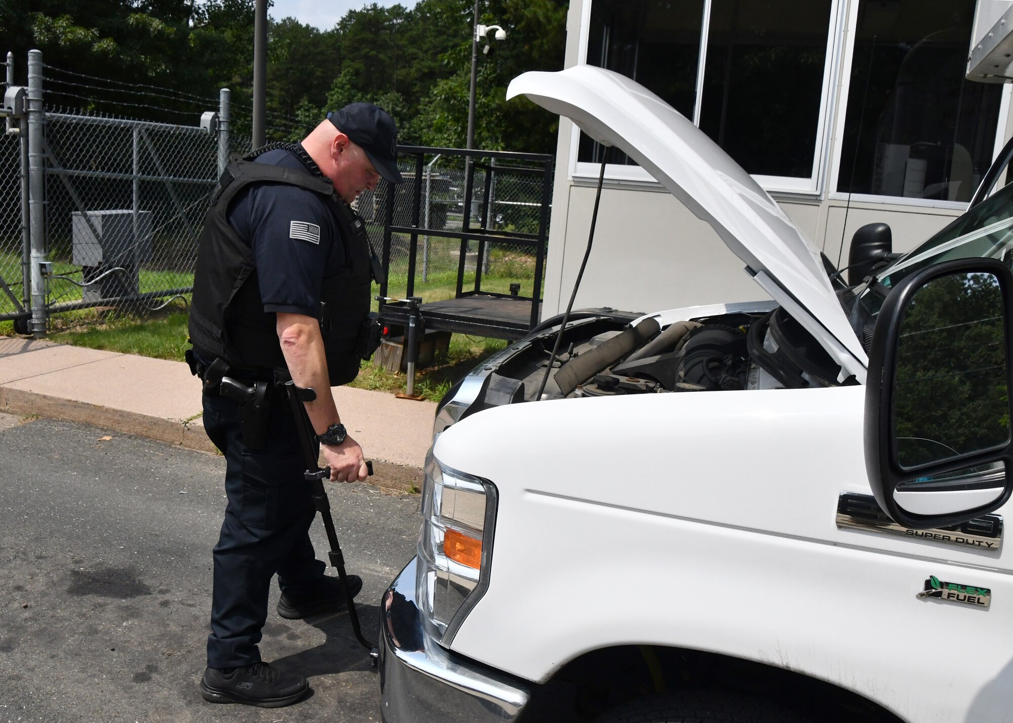 Officer Robert Keeler, 104th Fighter Wing Installation Security Officer, inspects a commercial vehicle looking for contraband July 21, 2021, at Barnes Air National Guard Base, Massachusetts. Keeler works with other civilian officers and military defenders to ensure safety on base.  (U.S. Air National Guard photo by Staff Sgt. Sara Kolinski)