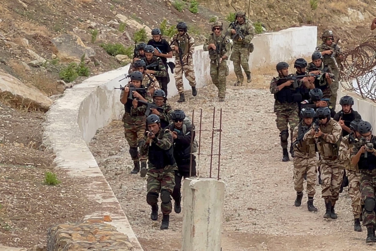 Troops move along a dirt road.