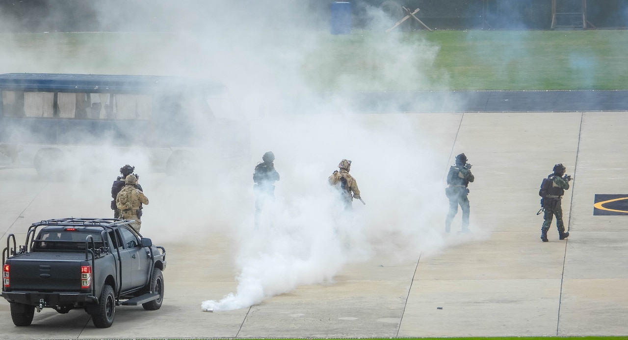 Troops move through smoke.