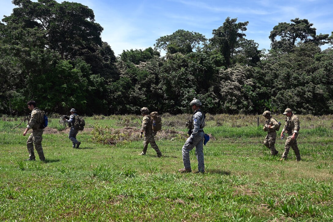 Soldiers walk across a field.