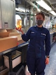 Serving aboard NOAA Ship Reuben Lasker, U.S. Coast Guard officer Lt.j.g. Rebecca Edmonds holds a sample of plankton that is submerged in a preservation fluid