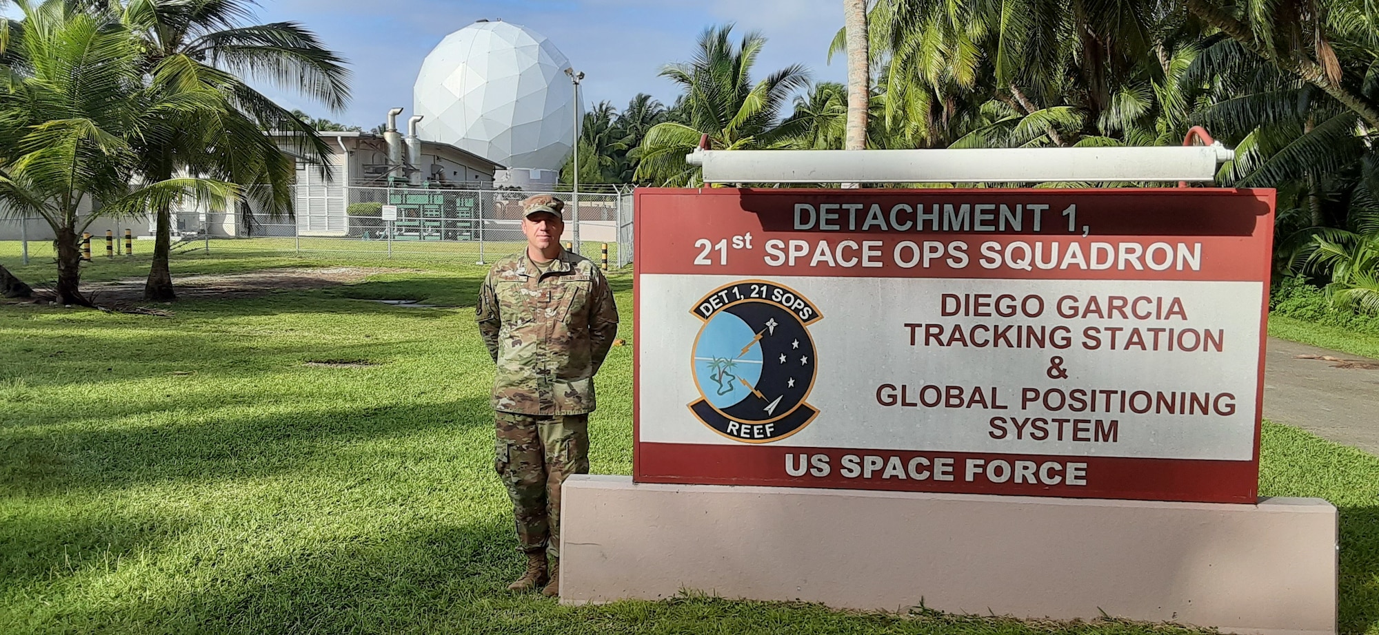 man posing next to sign