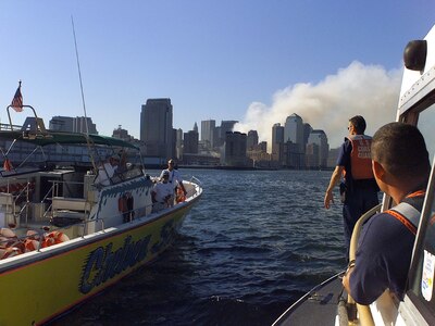 A Coast Guard boarding team aboard a 41-footer looks over a privately owned vessel in New York Harbor as the World Trade Center site burns in the background.  USCG Photo by PA3 Tom Sperduto, USCG.