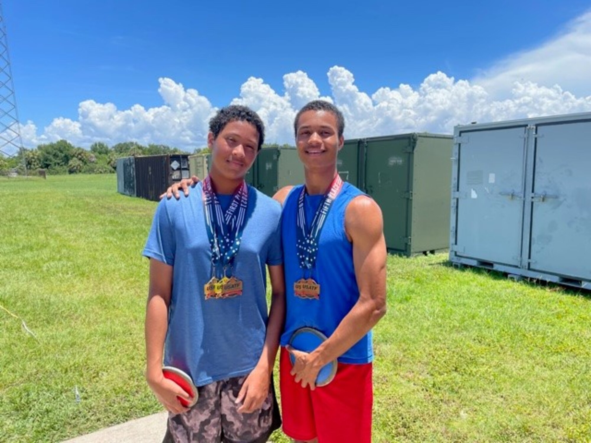 Benjamin Hiestand, left, a student at Tinker K-8 School, MacDill Air Force Base, Florida, and his brother Edward Hiestand Jr., pose for a photo near the large field at MacDill Air Force Base, Florida, with medals they won during the United States of America Track and Field (USATF) Youth Nationals in Rome, Georgia, June 2021.  Hiestand and his brother have been training on base to prepare for the USATF Junior Olympics beginning July 26.