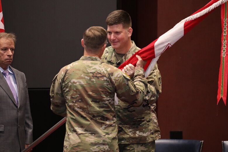 Maj. Gen. Jeffrey L. Milhorn, right, deputy commanding general for military and international operations of the U.S. Army Corps of Engineers, presents Huntsville Center’s colors to Col. Sebastien P. Joly during a change of command ceremony at Bob Jones Auditorium on Friday, July 23. (Photo by Michael May)